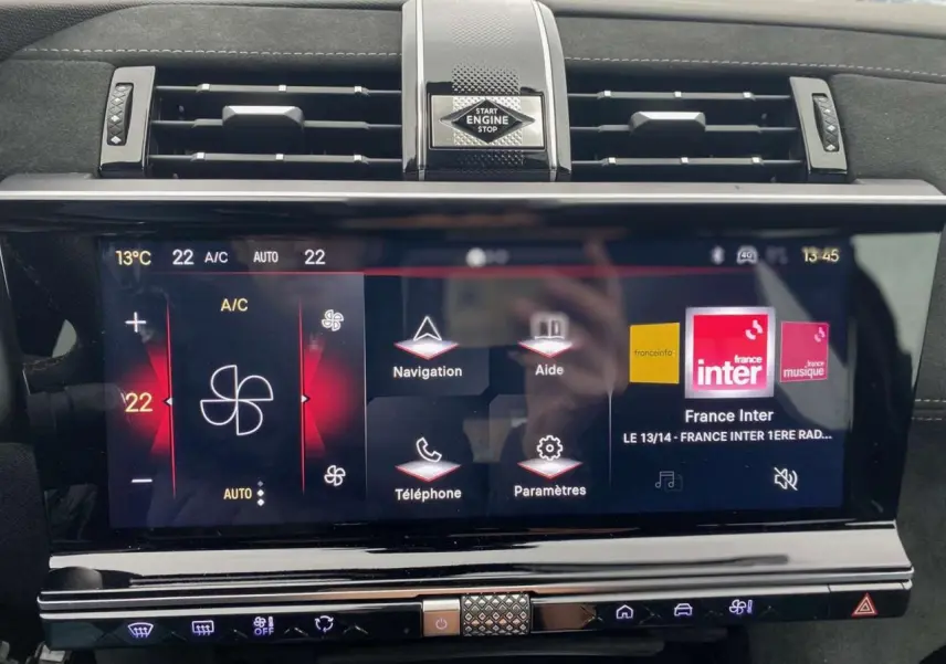 Vue rapprochée de l’écran tactile central du DS7 Crossback gris foncé, affichant la climatisation et les options multimédias.