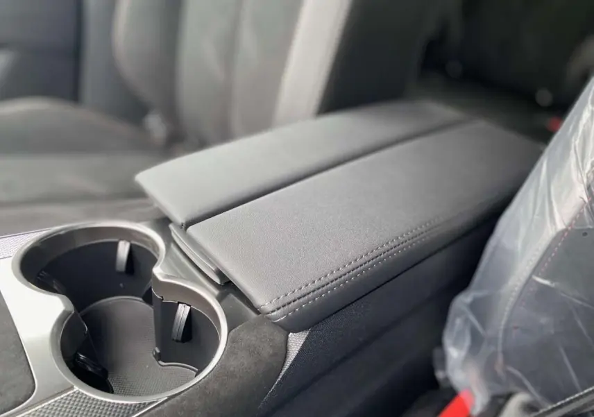 Gros plan sur l'accoudoir central et porte-gobelets en cuir gris foncé à l'intérieur du DS7 Crossback 2024 Performance Line+.