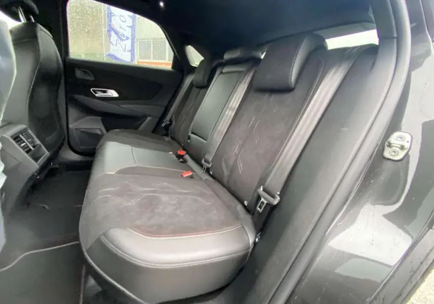 Vue intérieure arrière droite du DS7 Crossback 2024 gris foncé, montrant les sièges en cuir et alcantara avec surpiqûres contrastées.