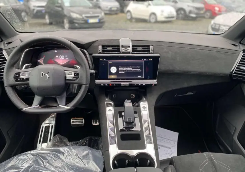 Vue intérieure avant du DS7 Crossback 2024 gris foncé, mettant en valeur le tableau de bord numérique et la console centrale moderne.