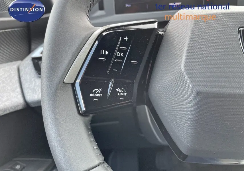 Gros plan sur les commandes gauche du volant cuir noir du Peugeot 3008 Hybrid 2025, avec boutons d'assistance et limitation.