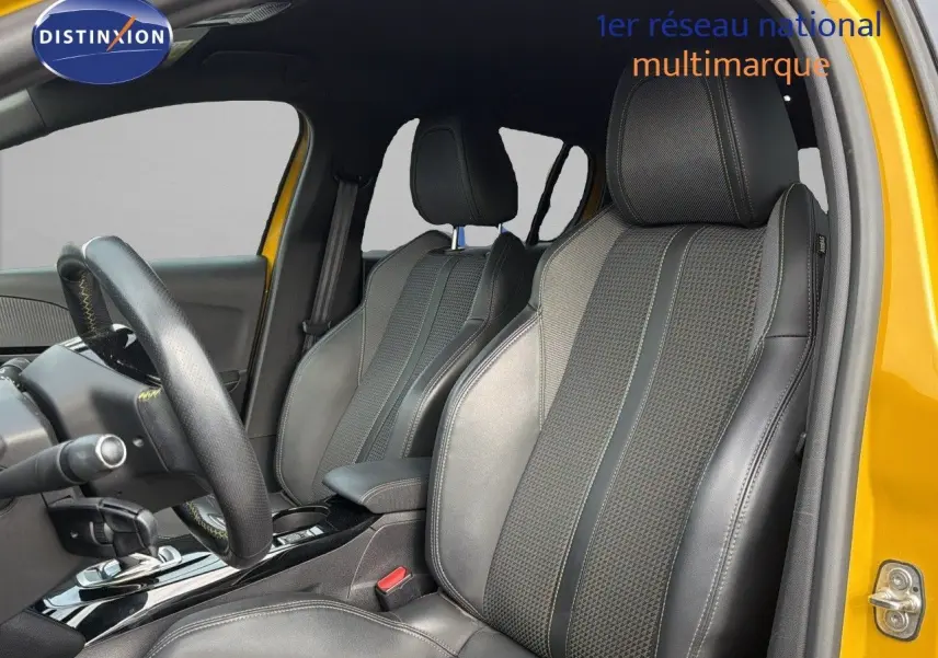 Vue intérieure côté conducteur de la Peugeot 208 électrique jaune Faro avec sièges en cuir noir et surpiqûres jaunes.