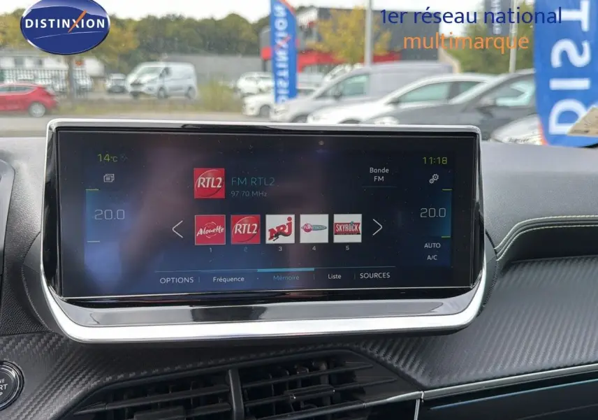 Écran tactile central affichant les stations radio FM dans l'habitacle d'une Peugeot 208 électrique 2020.