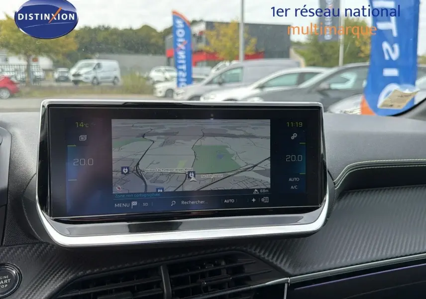 Écran tactile central affichant la navigation dans l'habitacle d'une Peugeot 208 électrique jaune Faro métal avec toit noir.