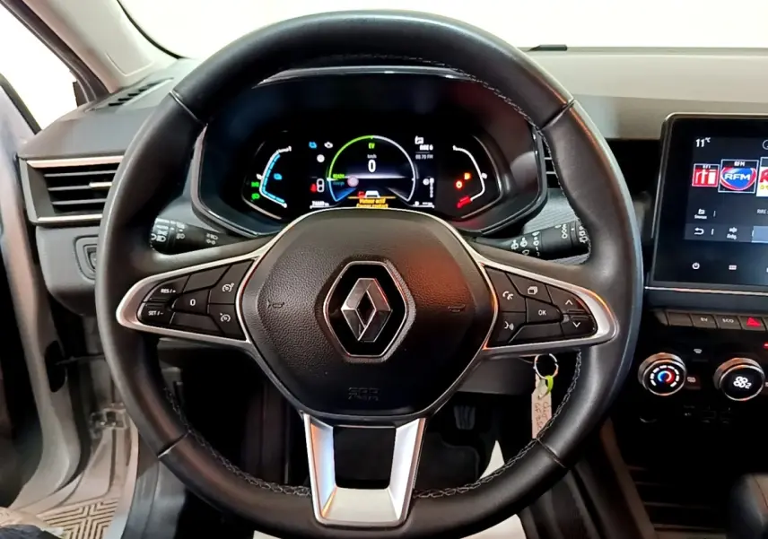 Vue intérieure centrée sur le volant cuir noir et le tableau de bord numérique de la Renault Clio Business E-TECH 140 gris foncé.