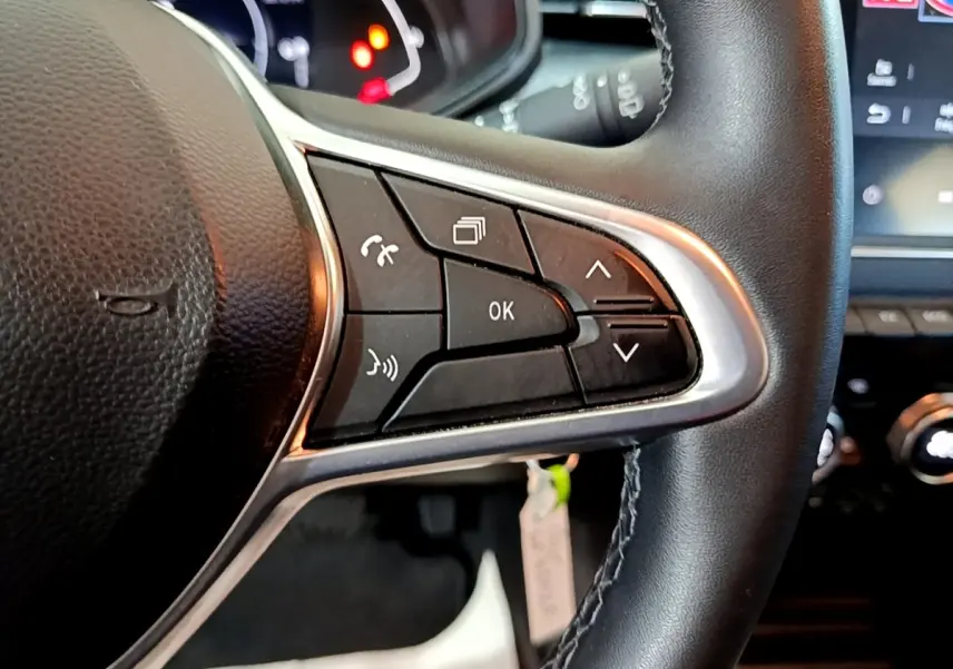 Gros plan sur les commandes multifonctions du volant en cuir noir de la Renault Clio Business E-TECH 140 gris foncé, 2022.