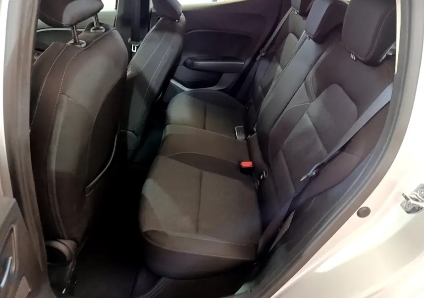 Vue côté droit sur la banquette arrière noire de la Renault Clio Business E-TECH 140, sièges tissu et ceinture de sécurité visible.