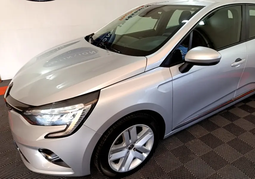 Vue 3/4 avant droit d'une Renault Clio Business E-TECH 140 gris clair avec feux LED et jantes alliage.
