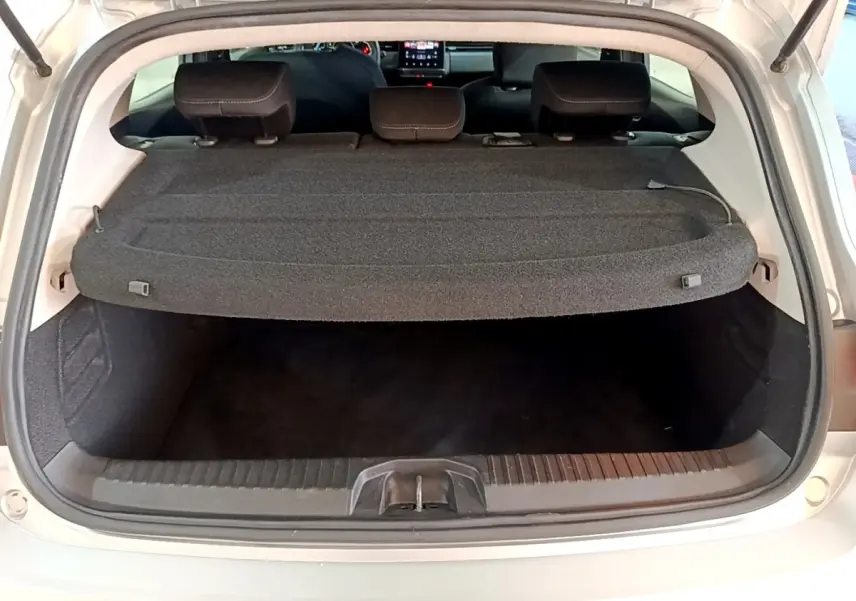 Coffre ouvert d'une Renault Clio gris foncé, vue arrière montrant la tablette cache-bagages et banquette rabattable.