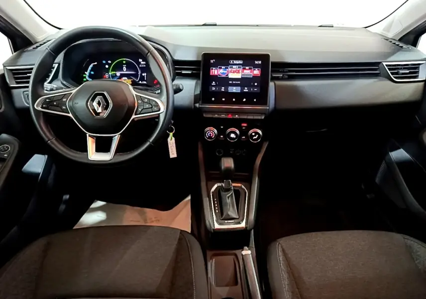 Vue intérieure frontale du tableau de bord de la Renault Clio Business E-TECH 140, avec volant multifonctions et écran tactile central.