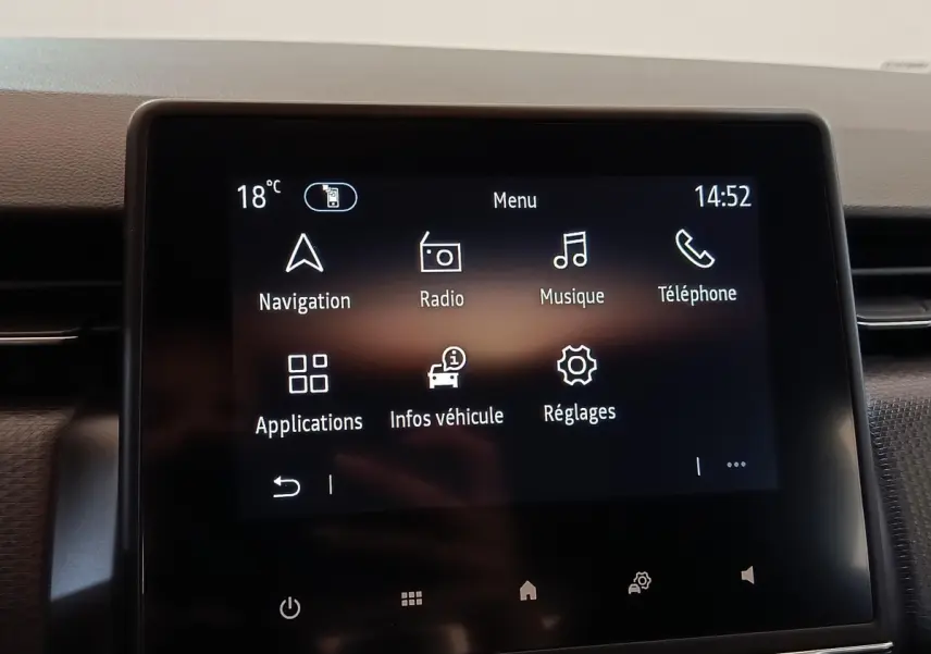Écran tactile central de la Renault Clio Business blanc, affichant le menu principal avec navigation et radio.