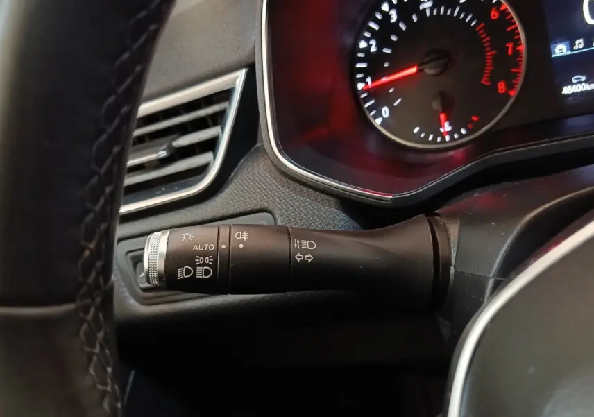 Gros plan sur la manette de commande des phares et clignotants côté gauche du tableau de bord de la Renault Clio Business blanche 2021.