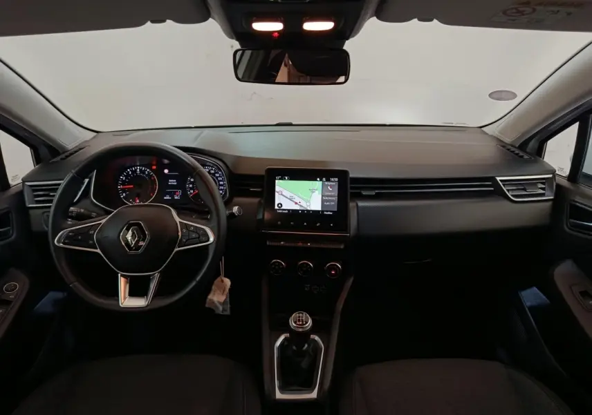 Vue intérieure avant du tableau de bord de la Renault Clio Business blanche 2021 avec volant multifonctions cuir et écran tactile central.