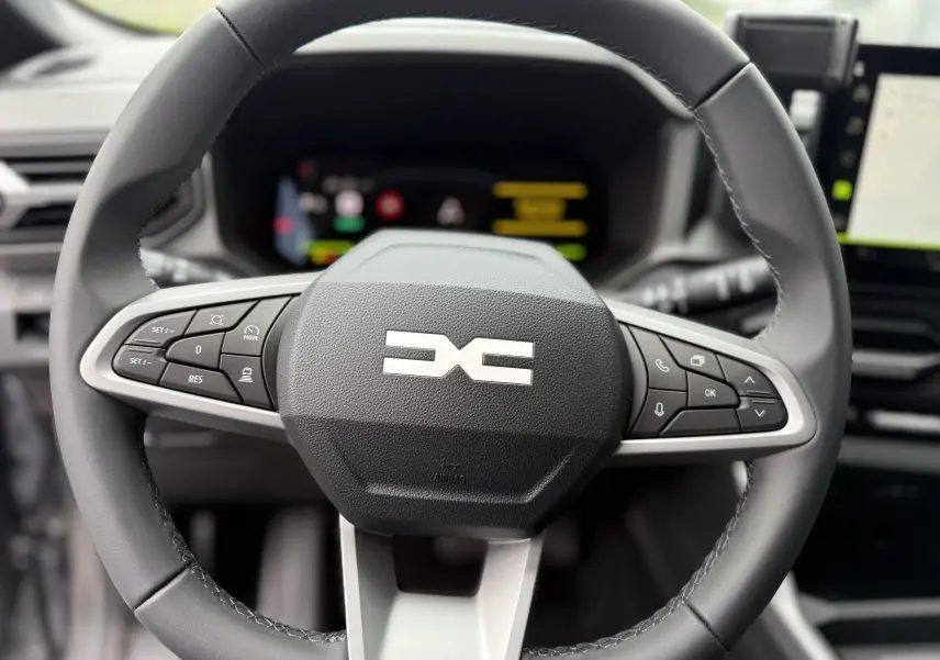 Vue rapprochée du volant noir du Dacia Bigster 2026 avec commandes intégrées et logo central distinctif.