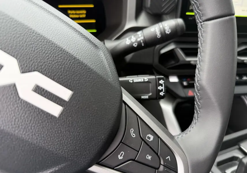 Gros plan sur le volant gris du Dacia Bigster 2026 avec commandes intégrées et partie du tableau de bord visible.