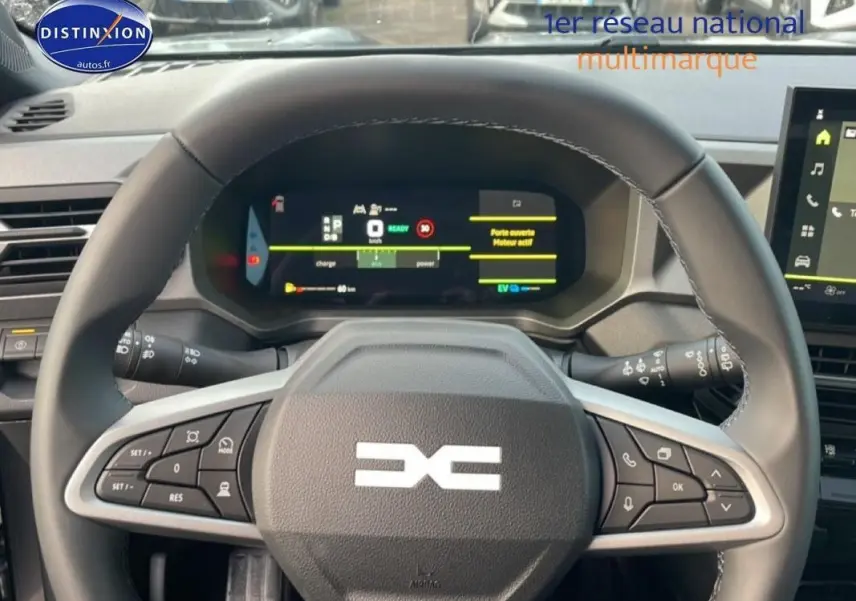 Vue intérieure centrée sur le volant du Dacia Bigster 2026, avec tableau de bord numérique et commandes au volant visibles.