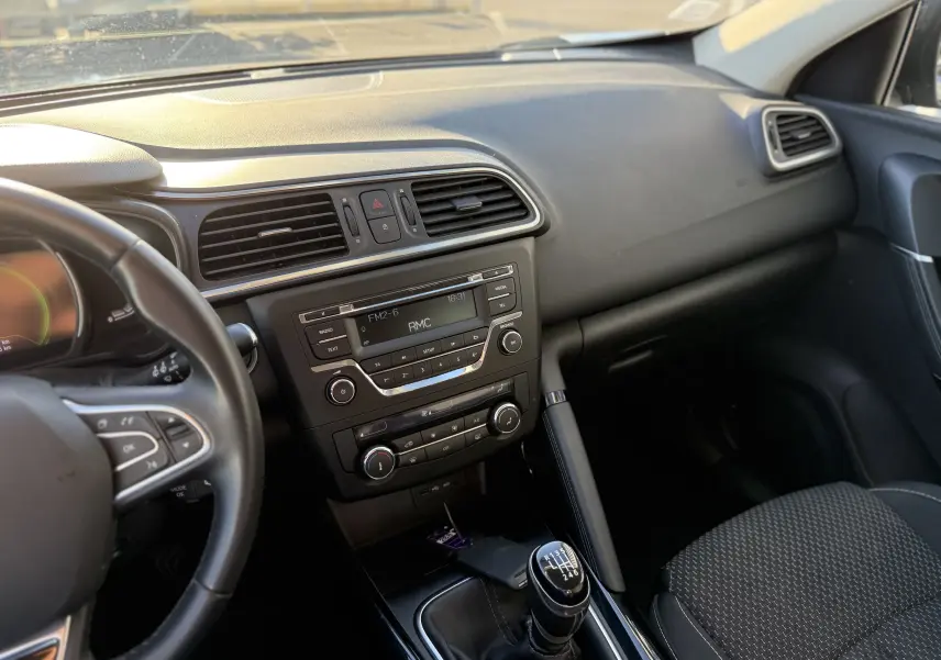 Vue intérieure côté conducteur du Renault Kadjar bleu 2019, mettant en valeur la console centrale avec boîte manuelle et tableau de bord noir.
