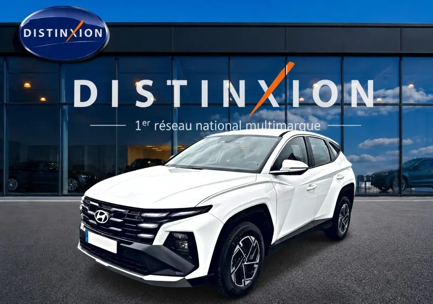 Hyundai Tucson blanc 2026 en 3/4 avant droit, avec calandre noire et jantes alliage 17 pouces visibles.