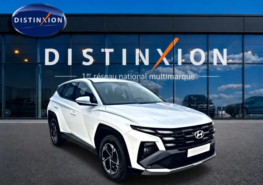 Hyundai Tucson blanc 2026 en 3/4 avant droit, avec calandre noire et jantes alliage 17 pouces visibles.