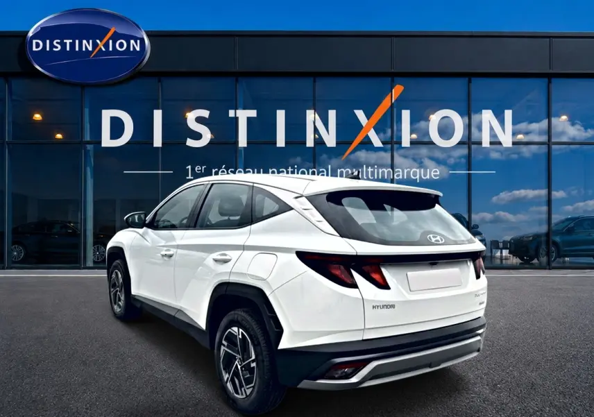 Vue 3/4 arrière droite du Hyundai Tucson blanc hybride 2026 avec jantes alliage et feux arrière LED distinctifs.