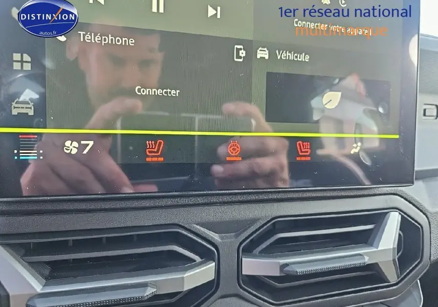 Écran tactile du tableau de bord du Dacia Duster 2025 avec commandes climatisation et sièges chauffants visibles.