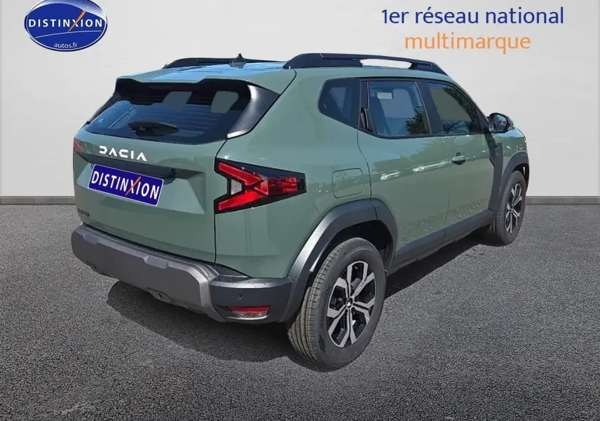 Vue 3/4 arrière droite du Dacia Duster 2025 vert kaki avec jantes alu et barres de toit noires.