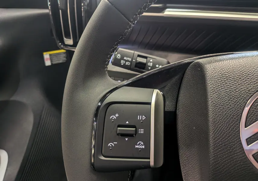 Gros plan sur le volant noir du Citroën C3 Aircross hybride 2025, montrant les commandes de régulateur de vitesse côté gauche.