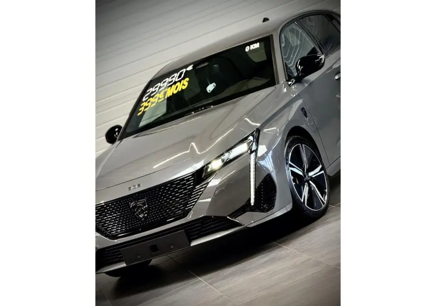 Vue 3/4 avant droit de la Peugeot 308 gris sélénium avec calandre noire brillante et jantes alliage 18 pouces.