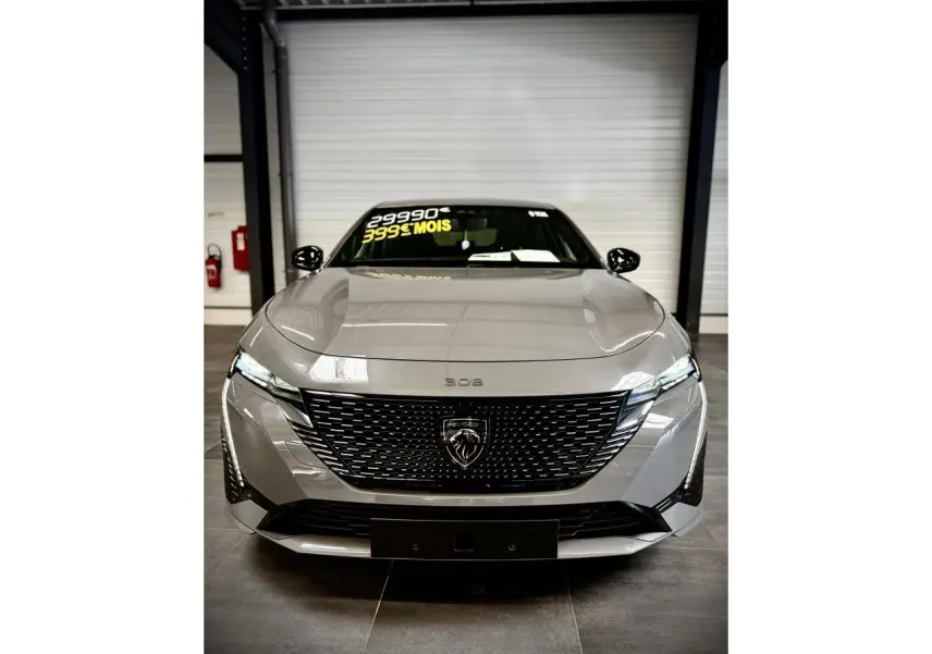 Vue avant de la Peugeot 308 GT gris selenium avec calandre noire brillante et feux LED griffés.