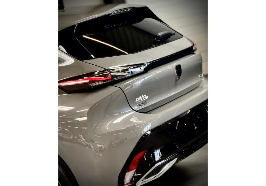 Vue 3/4 arrière droite d'une Peugeot 308 GT gris selenium avec feux arrière LED et bandeau noir brillant.