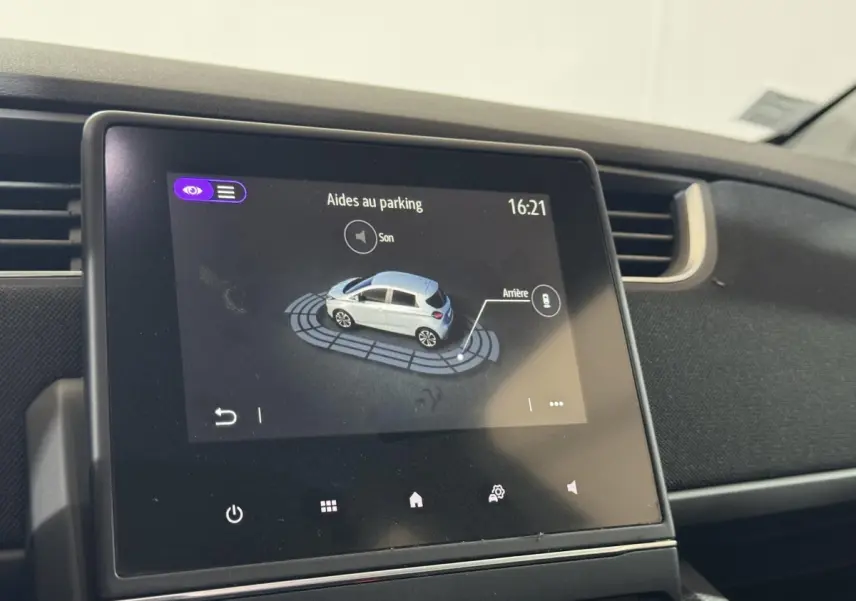 Écran tactile central montrant l'aide au stationnement de la Renault ZOE blanche, vue intérieure du tableau de bord.