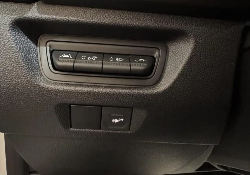 Détail des boutons de commande noirs sur tableau de bord intérieur de la Renault ZOE blanche 2020.