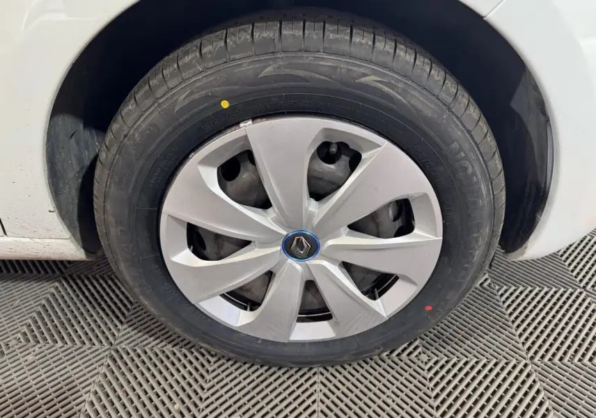 Gros plan sur la roue avant droite blanche d’une Renault ZOE 2020 avec enjoliveur gris et logo Renault central.