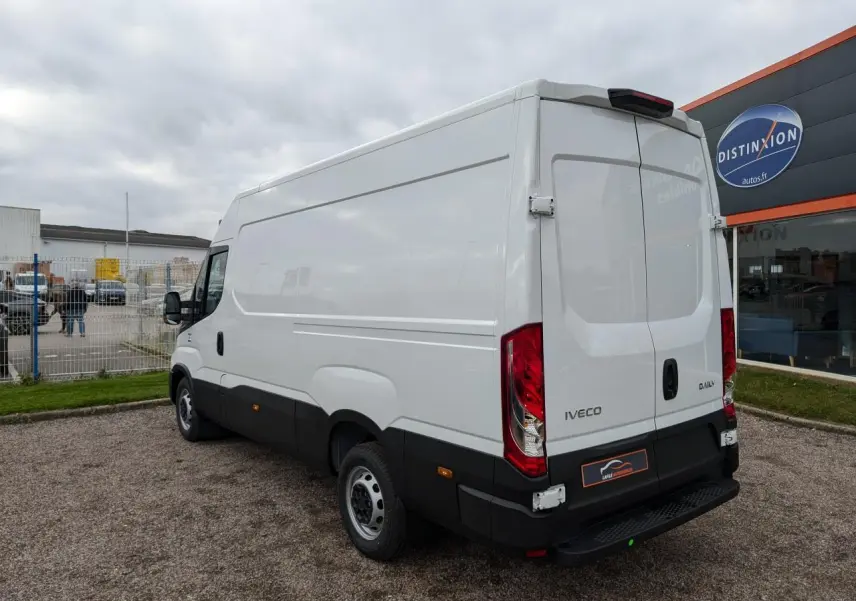 Vue 3/4 arrière droite du fourgon Iveco Daily blanc avec portes arrière doubles et bas de caisse noir.