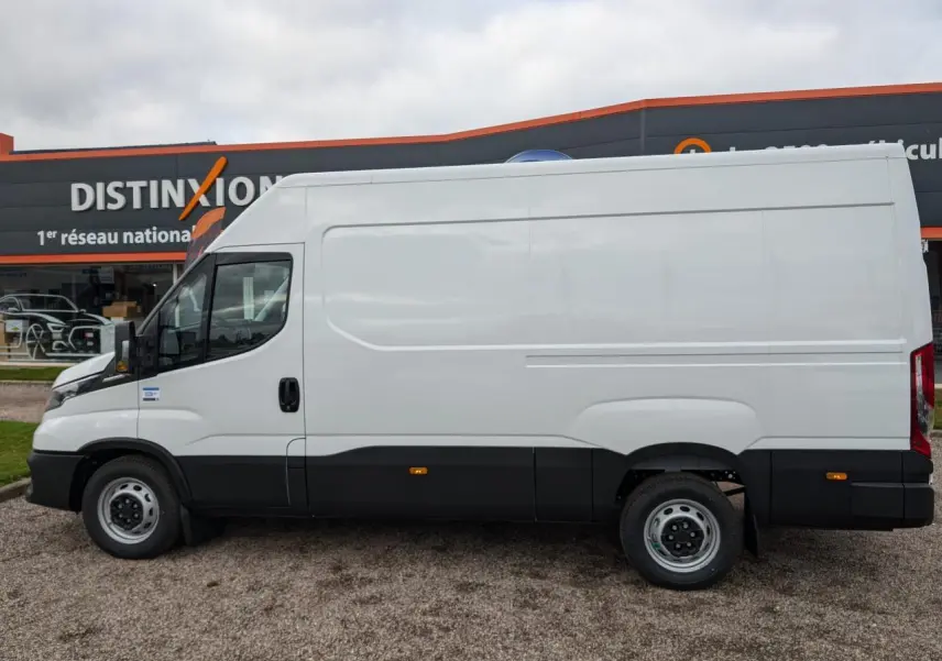 IVECO Daily blanc en vue de profil côté gauche, avec bas de caisse noir et porte coulissante sans fenêtre.