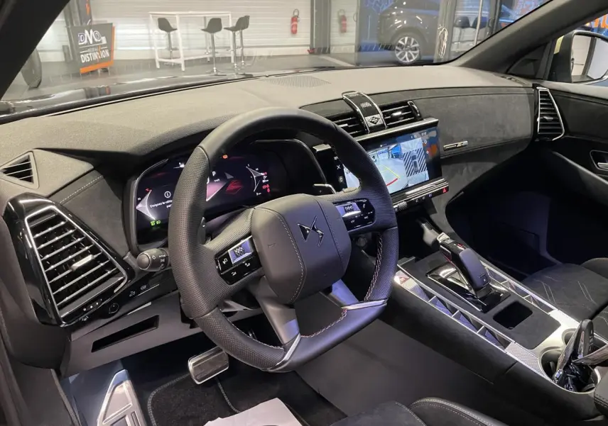 Vue intérieure côté conducteur du DS7 Crossback 2026, volant cuir perforé, tableau de bord numérique et console centrale en Alcantara noir.