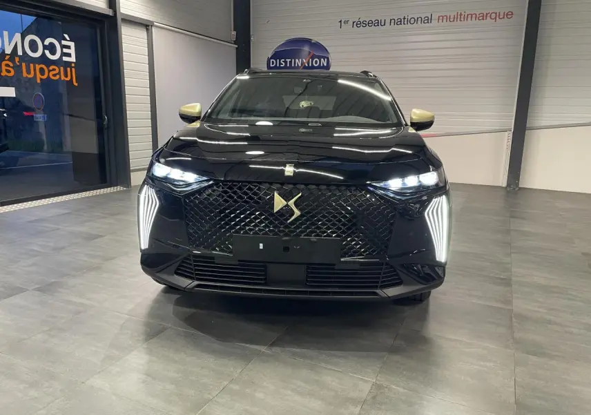 Vue frontale d'un DS7 Crossback noir métallisé avec calandre DS Wings et feux LED verticaux allumés.