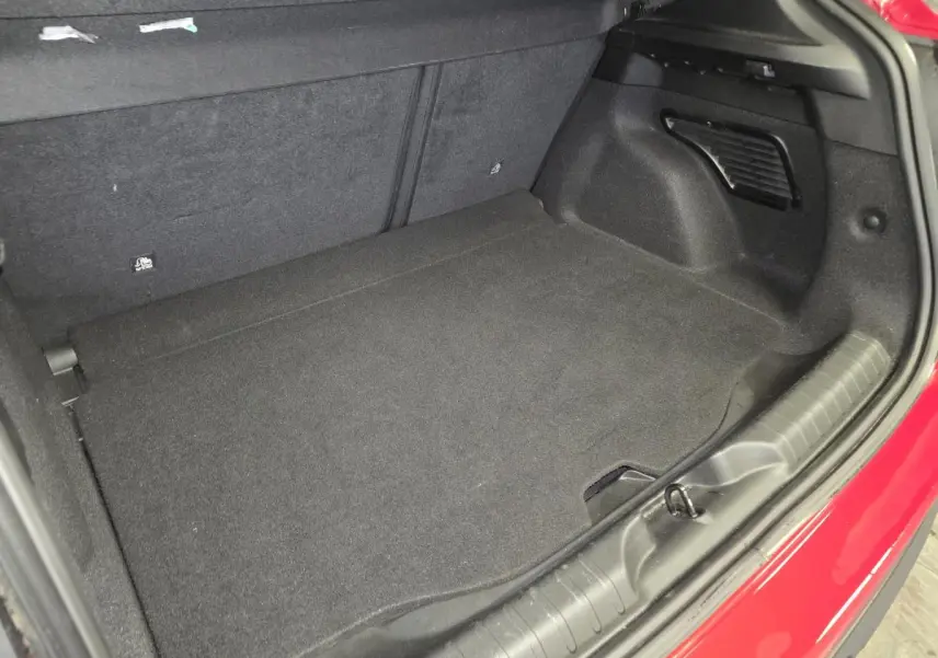 Coffre ouvert vu de l'arrière droit d'une FIAT 600 1.2 Hybrid rouge, avec tapis de sol noir et garnitures intérieures.