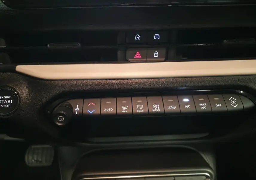Vue rapprochée de la console centrale noire et beige du Fiat 600 rouge 2024, avec commandes climatisation et bouton start/stop.