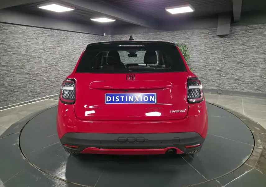 Vue arrière d'une FIAT 600 rouge 2024 avec feux arrière LED et logo Hybrid sur hayon.