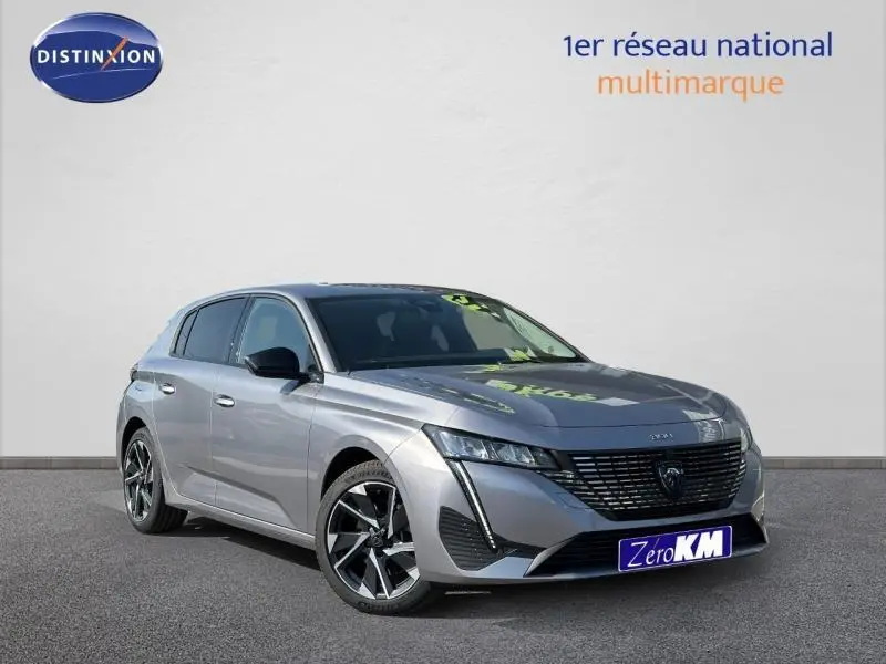 Peugeot 308 gris Artense vue 3/4 avant droit avec jantes alu et calandre noire distinctive.