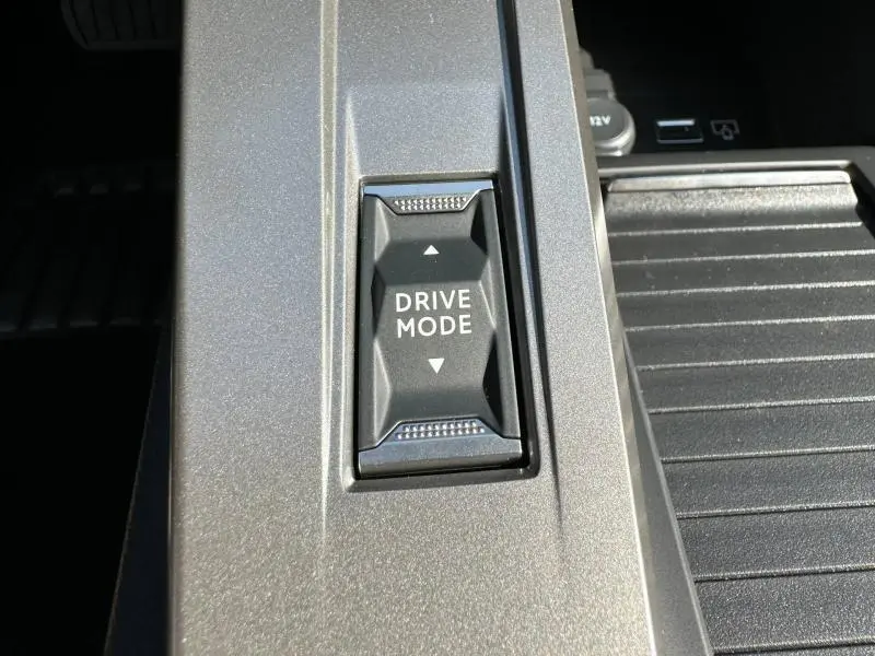 Gros plan sur le bouton Drive Mode intégré dans la console centrale gris Artense d'une Peugeot 308 2025.