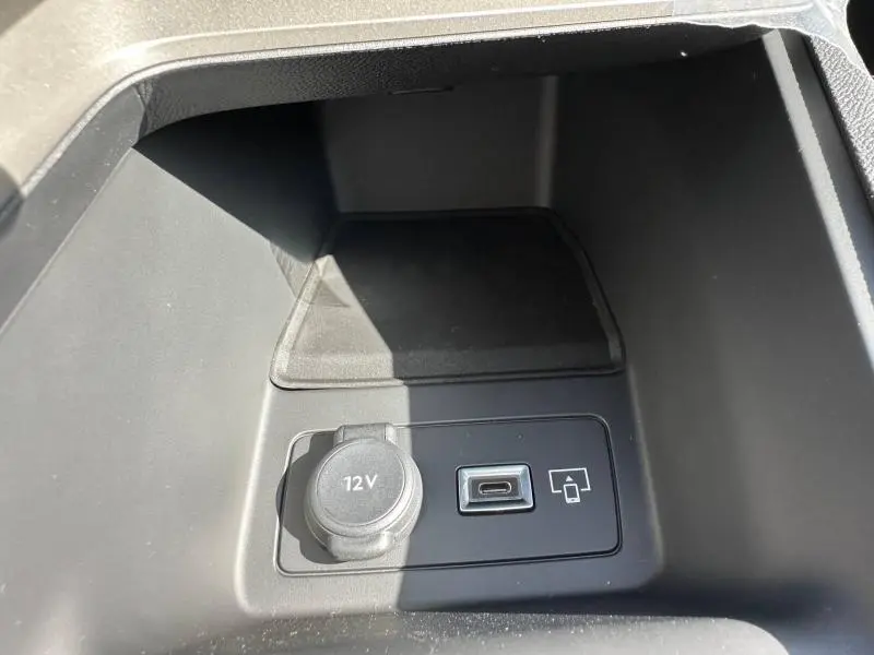 Gros plan sur la prise 12V et port USB dans le rangement central intérieur du Peugeot 308 gris Artense.