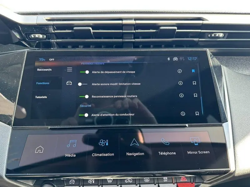 Écran tactile central de la Peugeot 308 2025 affichant les alertes de sécurité et les fonctions multimédia, vue intérieure.