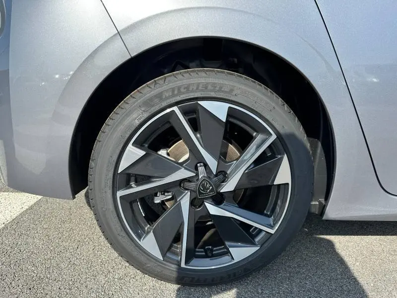 Gros plan sur la jante alu noire et grise du côté arrière droit d’une Peugeot 308 gris Artense.