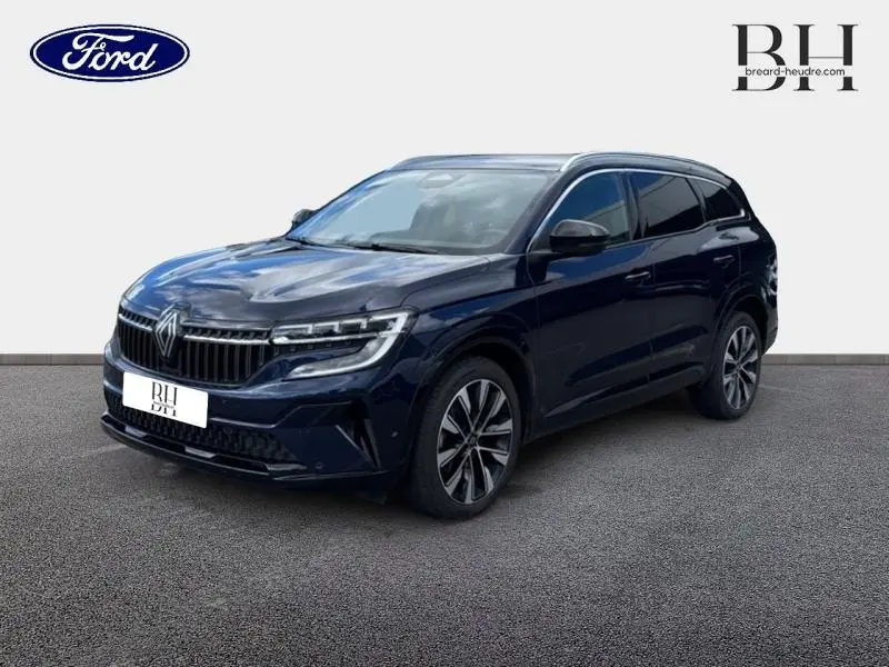 Renault Espace 2024 bleu foncé en 3/4 avant droit, avec jantes alliage et vitres arrière surteintées.