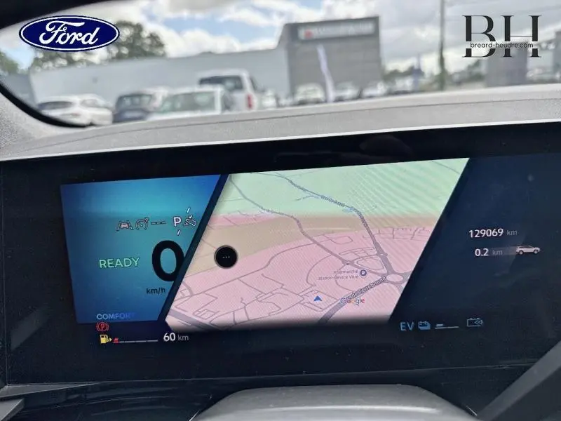 Tableau de bord avec écran tactile et affichage numérique du GPS d'une Renault Espace rouge, version hybride 2024.
