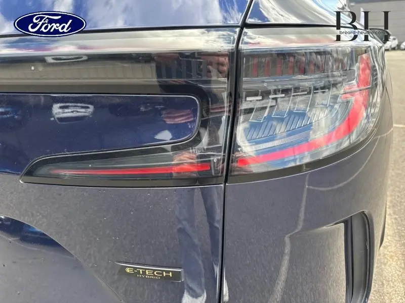 Gros plan sur le feu arrière droit rouge et noir d'un Renault Espace 1.2 E-Tech full hybrid 2024 bleu foncé.