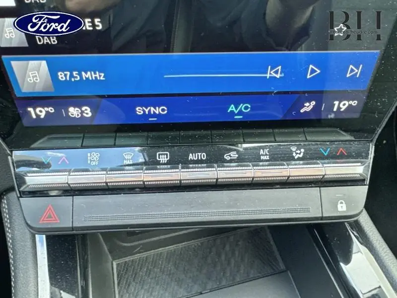 Panneau de commande de climatisation et écran tactile d’un Renault Espace rouge, vue intérieure centrée.