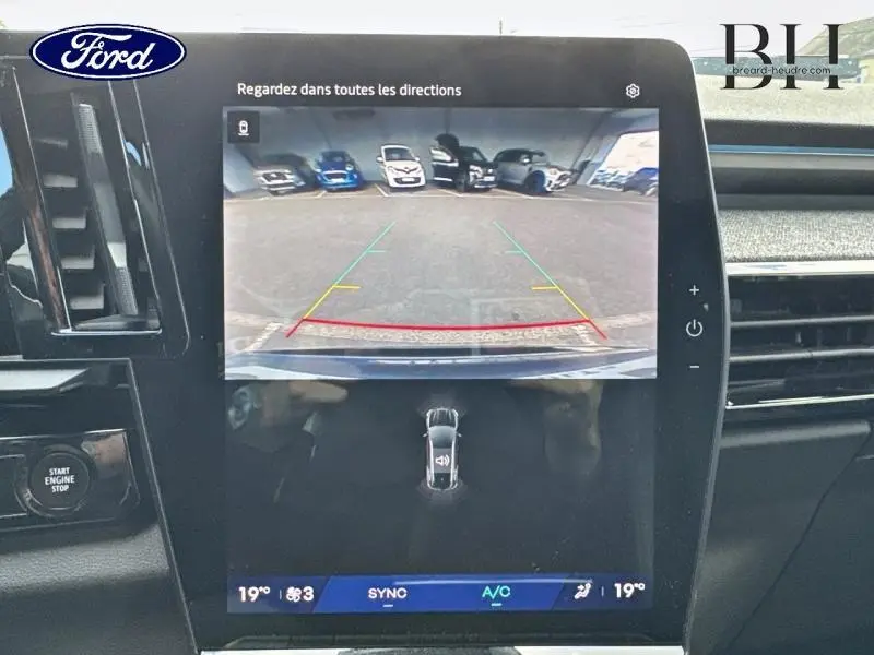 Écran tactile intérieur montrant la caméra de recul d’un Renault Espace rouge, vue de face du tableau de bord.
